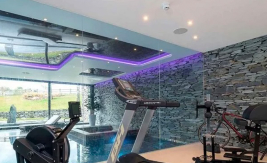 Este es uno de los espacios más espectaculares de la casa. El gimnasio que tiene vista a la piscina y el jacuzzi.